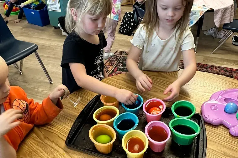 kids coloring eggs for easter.