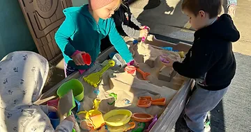 Kids playing at a sand table