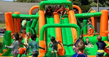 Many kids playing at a water slide